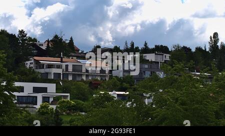 Attraente zona residenziale sulla cima di una collina nella città Esslingen am Neckar, Baden-Württemberg, Germania con moderne case di lusso circondate da alberi. Foto Stock