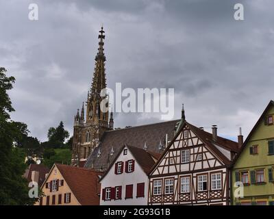 Scuderie di vecchie case a graticcio nel mercato storico di Esslingen am Neckar, Baden-Württemberg, Germania con il campanile della chiesa Frauenkirche. Foto Stock