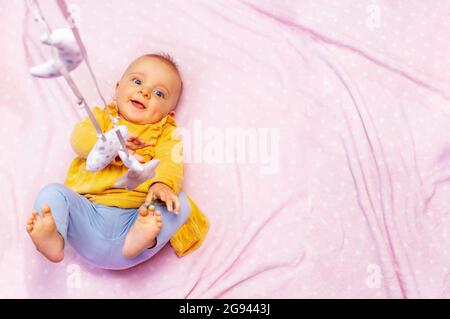 La bambina gioca con i giocattoli mobili dall'alto Foto Stock