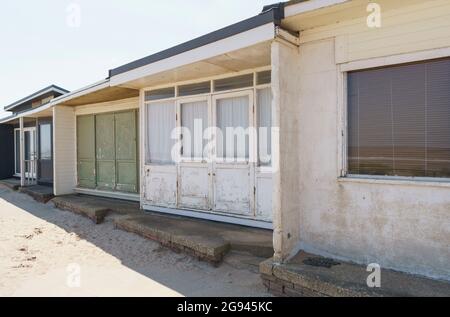 Vista panoramica di una linea di chalet meteorici sulla spiaggia, Sutton-on-Sea, Lincolnshire, UK, giugno Foto Stock