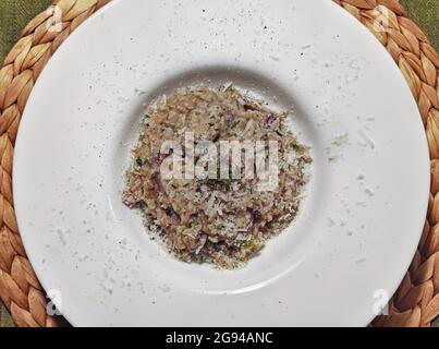 Elegante piatto bianco con risotto con funghi porcini, cucina tipica italiana Foto Stock