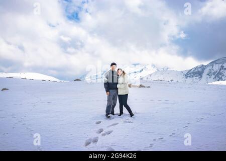 la giovane coppia che si tiene a vicenda sulle montagne innevate da un'immagine ad angolo basso è presa al passo bumla arunachal pradesh india. Foto Stock