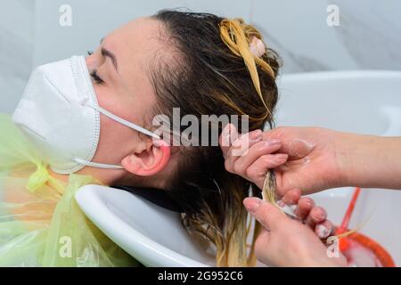 Sciacquare i capelli dopo lo shampoo, cura dei capelli nel barbiere, visitare il parrucchiere durante la quarantena. Nuovo Foto Stock