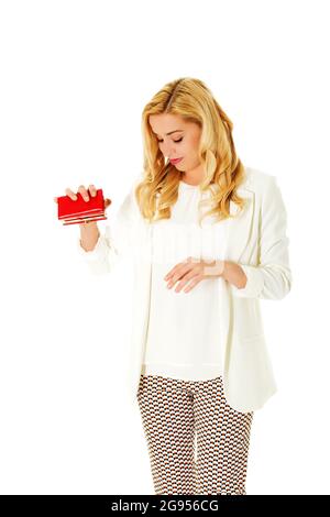 Bella caucasian business donna controllando il suo vuoto portafoglio rosso. Isolato su bianco. Foto Stock