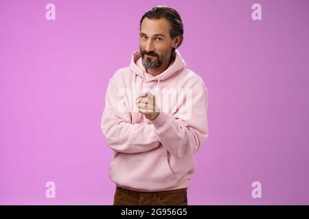 Uomo carismatico e carismatico in elegante felpa con cappuccio rosa invitandoli ad unirsi all'azienda sorridente auto-assicurato indicando che il selezionamento fa Foto Stock