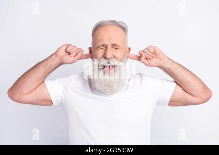 Ritratto di attraente funky uomo di mezza età che chiude le orecchie urlando evitando il conflitto isolato su sfondo bianco colore pastello Foto Stock