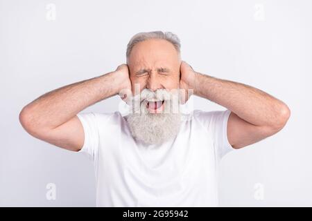 Ritratto di attraente uomo matto di mezza età che chiude le orecchie gridando isolato su sfondo bianco colore pastello Foto Stock