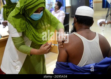 Un operatore sanitario inocula un uomo con una dose del vaccino Moderna contro il coronavirus Covid-19 presso l'ospedale di Dhaka, Bangladesh, il 24 luglio 2021 Foto Stock