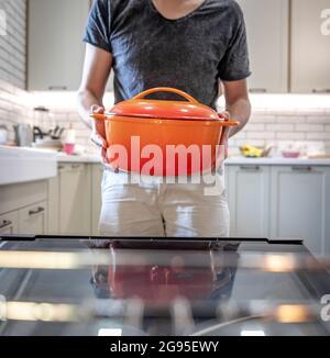 Un uomo tiene un piatto in mano prima di metterlo in forno. Foto Stock