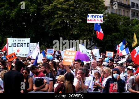 I manifestanti detengono bandiere e cartelli durante una protesta contro la vaccinazione obbligatoria per alcuni lavoratori e l'uso obbligatorio del certificato sanitario richiesto dal governo francese, sulla spianata 'Droits de l'homme' (diritti umani) in piazza Trocadero a Parigi, Francia, il 24 luglio 2021. Dal luglio 21, le persone che vogliono andare in gran parte degli spazi pubblici in Francia devono mostrare una prova di vaccinazione Covid-19 o un test negativo, in quanto il paese si brace per un temuto picco nei casi della variante altamente trasmissibile del delta Covid-19. Foto Stock