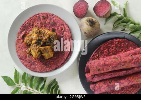 La barbabietola Paratha è un pane piatto di grano integrale fritto in padella indiana fatto di farina di grano impastata con barbabietole grattugiate fresche e spezie. Servito con pollo gr Foto Stock