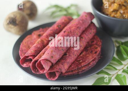 La barbabietola Paratha è un pane piatto di grano integrale fritto in padella indiana fatto di farina di grano impastata con barbabietole grattugiate fresche e spezie. Servito con pollo gr Foto Stock