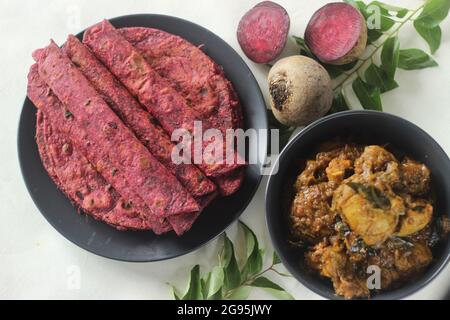 La barbabietola Paratha è un pane piatto di grano integrale fritto in padella indiana fatto di farina di grano impastata con barbabietole grattugiate fresche e spezie. Servito con pollo gr Foto Stock