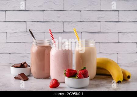 Set di fragole banana e cioccolato milkshake nei vasi di vetro Foto Stock