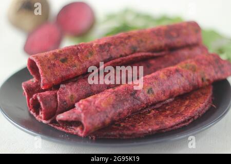 La barbabietola Paratha è un pane piatto di grano integrale fritto in padella indiana fatto di farina di grano impastata con barbabietole grattugiate fresche e spezie. Girato su sfondo bianco Foto Stock