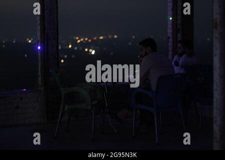 23 luglio 2021: Le immagini mostrano un gruppo di giovani siriani seduti sulla cima di Jabal al-Arbaeen che domina la città di Idlib e la sua campagna, dove la montagna era una destinazione turistica prima della rivoluzione siriana a causa della sua posizione bella e strategica, dopo di che è stato sottoposto ad intensi bombardamenti da parte delle forze di regime, che hanno portato alla distruzione di molti edifici in esso. Nonostante ciò, i giovani continuano a trascorrere un po' di tempo lì nonostante il pericolo di bombardamenti (Credit Image: © Moawia Atrash/ZUMA Press Wire) Foto Stock