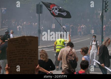 Gilet Jaune (giallino) con una bandiera pirata, e l'iscrizione 'Révolution sociale' tra fumo lacrimogeno. Il 24 luglio 2021, diverse migliaia di persone hanno sfidato il divieto prefetturale di dimostrare per la quarta volta, marciando per le strade di Tolosa (Francia). Cantando la parola "libertà", e gli slogan anti-Macron, i manifestanti hanno marciato sui viali del centro della città, protestando così contro il Passo sanitario e un obbligo di vaccinazione che non avrebbe detto il suo nome. Foto di Patrick Batard / ABACAPRESS.COM Foto Stock