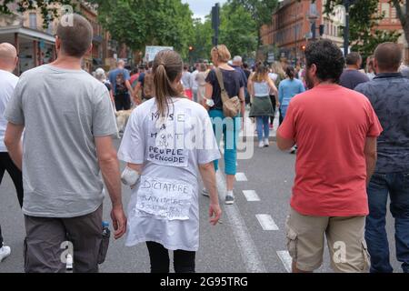 Protestore con iscrizione sul dorso circa il genocidio. Il 24 luglio 2021, diverse migliaia di persone hanno sfidato il divieto prefetturale di dimostrare per la quarta volta, marciando per le strade di Tolosa (Francia). Cantando la parola "libertà", e gli slogan anti-Macron, i manifestanti hanno marciato sui viali del centro della città, protestando così contro il Passo sanitario e un obbligo di vaccinazione che non avrebbe detto il suo nome. Foto di Patrick Batard / ABACAPRESS.COM Foto Stock