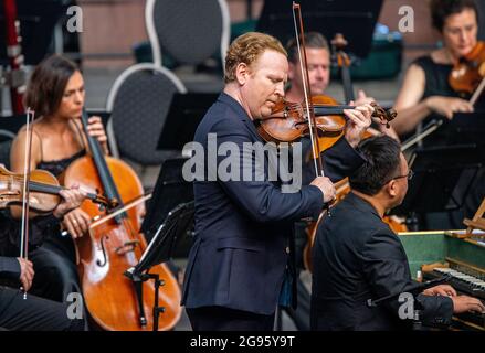 Redefin, Germania. 24 luglio 2021. La star del violino Daniel Hope suonerà con la Zurich Chamber Orchestra al Festival Concert presso lo Stud Nel corso del fine settimana si terranno quattro concerti nella sala di equitazione dell'azienda classicista. Sono ammessi al massimo 1250 ascoltatori. Prima del concerto, c'era il tradizionale picnic all'aperto e uno spettacolo di cavalli da guardare. Credit: Jens Büttner/dpa-Zentralbild/dpa/Alamy Live News Foto Stock