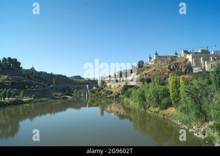 Spagna, Toledo, il bellissimo ponte storico di Alcantara. Il monumento si riflette nelle acque ferme del fiume Tago. Foto Stock