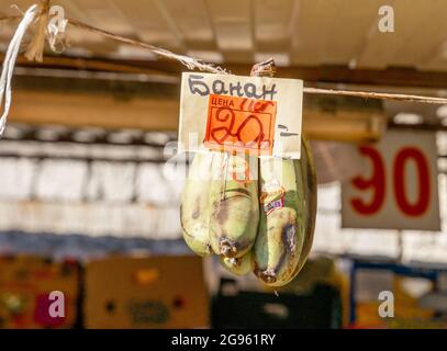 Le banane appese sulla corda in esposizione, vendute a 20 rubli un chilo, o 2,5 dollari, al mercato di Sennoy, il più economico a San Pietroburgo, Russia Foto Stock