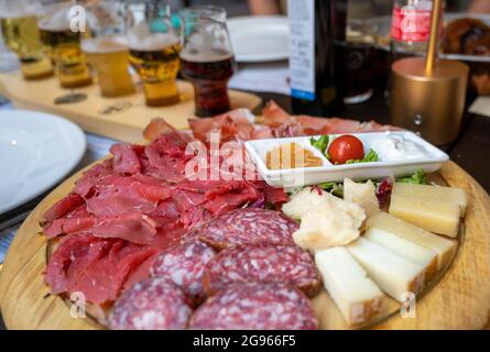 Un appetitoso piatto di salumi e formaggi assortiti con specialità trentine come lo speck, per accompagnare le salse. Concetto di i tipico e sano Foto Stock