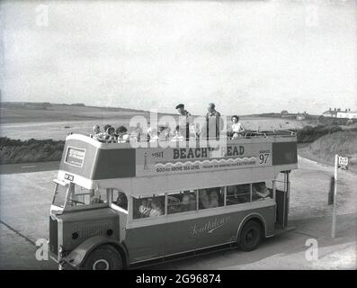 Anni '50, 'Visit Beachy Head'....persone su un autobus scoperto a due piani, un'utility Guy Arab, servizio 97, parcheggiato a Beachy Head, un promontorio sul South Downs a Eastbourne, East Sussex. La più alta scogliera di mare di gesso in Gran Bretagna, è circostante ondulato down sono un luogo famoso per il piacere di camminare, con vista sul canale inglese. Un'area di straordinaria bellezza naturale, nel 1929, la terra è stata acquistata per salvaguardarne l'uso per le generazioni future. Southdown Motors ha gestito la Route 97 da Royal Parade, Eastbourne, fino alla cima di Beachy Head, un servizio per gli escursionisti che risale alla prima guerra mondiale. Foto Stock