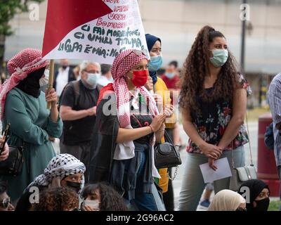 Ragazze con veli sulle loro teste e maschere chirurgiche sui loro volti durante un evento politico in Piazza pubblica con il segno più potente. Foto Stock