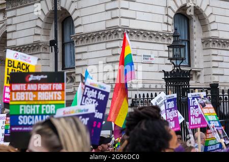 Bandiera arcobaleno e cartelloni con il segno di Downing Street sullo sfondo, durante la protesta di orgoglio reclamata, Londra, organizzata da Peter Tatchell Foto Stock
