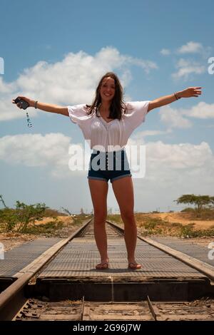 Uribia, la Guajira, Colombia - Maggio 28 2021: Donna caucasica posa su binari del treno vuoti Foto Stock