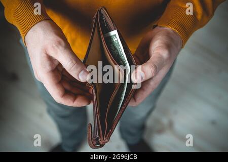 Portafoglio vuoto nelle mani di un giovane Foto Stock