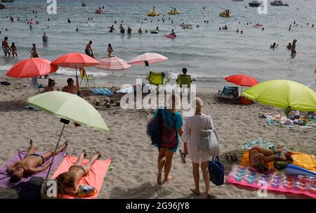 Calvia, Spagna. 24 luglio 2021. Gli ospiti arrivano alla spiaggia di Paguera a Maiorca. Dopo l'annunciato passaggio della Spagna all'area ad alta incidenza di Corona, inizialmente non ci sono indicazioni che un maggior numero di persone voglia annullare le proprie vacanze a Maiorca prematuramente o annullare i soggiorni prenotati. Credit: Clara Margais/dpa/Alamy Live News Foto Stock