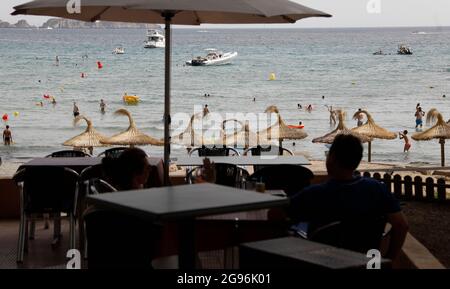 Calvia, Spagna. 24 luglio 2021. A Gasr si trova in un bar sulla spiaggia di Paguera a Maiorca. Dopo l'annunciato passaggio di categoria della Spagna all'area ad alta incidenza di Corona, inizialmente non ci sono indicazioni che un maggior numero di persone desideri annullare le vacanze a Maiorca in anticipo o annullare i soggiorni prenotati. Credit: Clara Margais/dpa/Alamy Live News Foto Stock