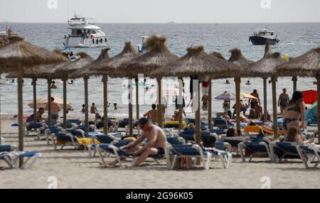 Calvia, Spagna. 24 luglio 2021. Gli ospiti si trovano sulla spiaggia di Paguera a Maiorca o nuotano. Dopo l'annunciato passaggio di Spagna all'area ad alta incidenza di Corona, inizialmente non ci sono indicazioni che un maggior numero di persone desideri annullare le vacanze di Maiorca prematuramente o annullare i soggiorni prenotati. Credit: Clara Margais/dpa/Alamy Live News Foto Stock