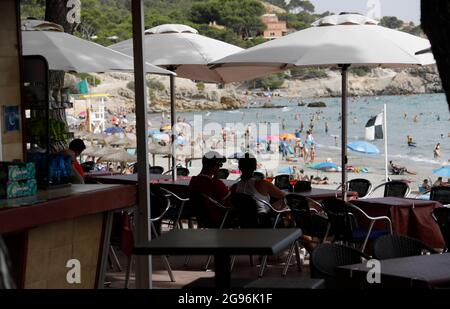 Calvia, Spagna. 24 luglio 2021. Potrete accomodarvi sulla spiaggia di Paguera, a Maiorca, in un bar. Dopo l'annunciato passaggio di categoria della Spagna all'area ad alta incidenza di Corona, inizialmente non ci sono indicazioni che un maggior numero di persone desideri annullare le vacanze a Maiorca in anticipo o annullare i soggiorni prenotati. Credit: Clara Margais/dpa/Alamy Live News Foto Stock