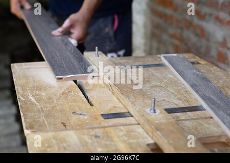Un uomo taglia una tavola di legno con un seghetto elettrico in un'officina  Foto stock - Alamy
