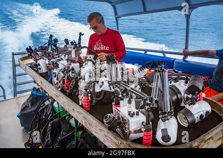 Un subacqueo (MR) controlla il suo alloggiamento della fotocamera sulla barca subacquea Manta Ray Bay Resorts con un tavolo per telecamere, Yap, Micronesia. Foto Stock