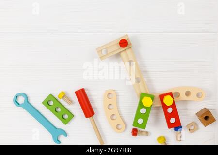 Una giraffa in legno colorato e kit da costruzione per bambini su legno. Set di attrezzi su tavolo di legno bianco. Giochi e strumenti per i bambini in età prescolare o in asilo Foto Stock