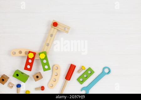 Una giraffa in legno colorato e kit da costruzione per bambini su legno. Set di attrezzi su tavolo di legno bianco. Giochi e strumenti per i bambini in età prescolare o in asilo Foto Stock