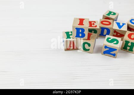 I blocchi di legno spiegano ABC su tavola di legno. Giochi e strumenti per i bambini in età prescolare o in asilo. Educazione, concetto di ritorno alla scuola Foto Stock