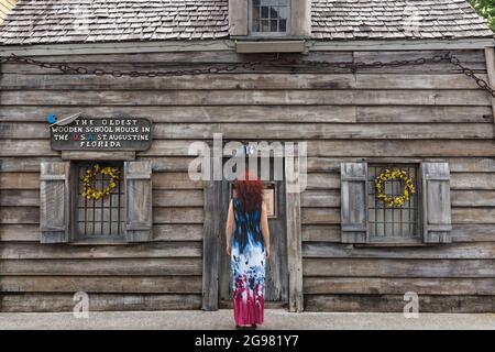 Donna che guarda la più antica Casa della Scuola di legno negli Stati Uniti, Saint Augustine, Florida, Stati Uniti Foto Stock