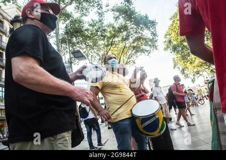 Barcellona, Spagna. 24 luglio 2021. I manifestanti hanno visto suonare i tipici strumenti musicali brasiliani durante la manifestazione.Sabato 24 luglio, giornata segnata dalle manifestazioni nelle principali città del Brasile contro il presidente brasiliano Jair Bolsonaro. I brasiliani che si trovano a Barcellona hanno tenuto una manifestazione sulle Ramblas di Barcellona per unirsi alle proteste del loro paese natale. Credit: SOPA Images Limited/Alamy Live News Foto Stock