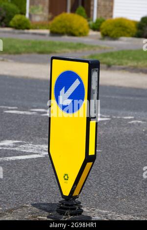 Tondino illuminato di colore giallo con segnaletica a sinistra, all'incrocio a T UK Foto Stock