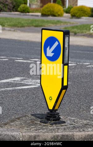 Tondino illuminato di colore giallo con segnaletica a sinistra, all'incrocio a T UK Foto Stock