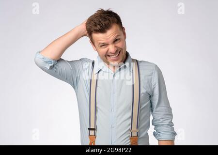 giovane uomo caucasico graffiando la testa, prendendo una decisione dura, Foto Stock