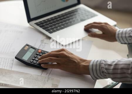 Primo piano visualizzare donna utilizzando il computer portatile e la calcolatrice che lavora sul report Foto Stock