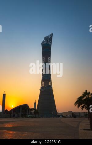 Doha, Qatar – 1 ottobre 2019: La Torch Tower nel complesso della città sportiva di Doha al tramonto accanto alla moschea di Aspire Masjid contro il cielo limpido Foto Stock