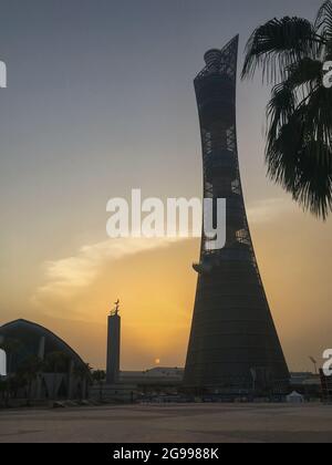 Doha, Qatar – 26 settembre 2019: La Torch Tower a Doha Sport City Complex al tramonto accanto alla moschea di Aspire Masjid contro il cielo nuvoloso Foto Stock