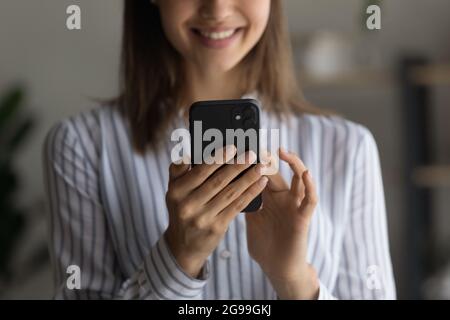Donna sorridente con smartphone, vista ravvicinata Foto Stock