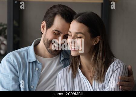 Bella coppia in amore abbracciando sedersi sul divano a casa Foto Stock